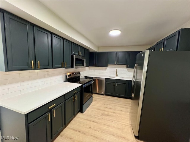 1779 E 236th St, Euclid, OH 4117 - kitchen featuring appliances with stainless steel finishes, a sink, light wood-type flooring, tasteful backsplash, and light countertops