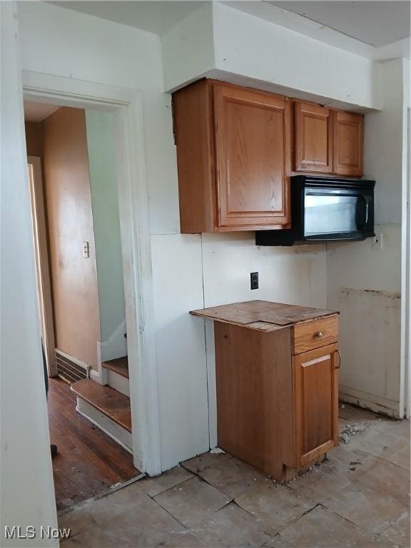 230 E 211th St, Euclid, OH 44123 - kitchen with brown cabinetry and black microwave
