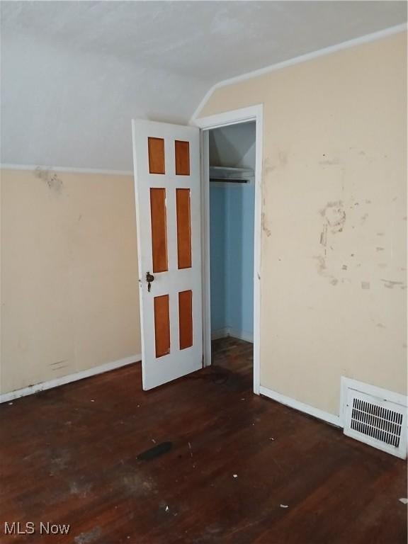 230 E 211th St, Euclid, OH 44123 - unfurnished bedroom with wood finished floors, vaulted ceiling, baseboards, and a closet