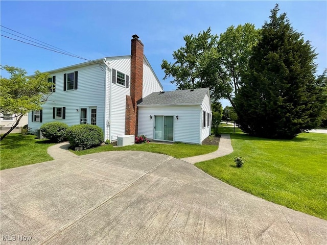 180 Atterbury Blvd, Hudson, OH 44236 - view of front facade with a front yard, a chimney, and central AC unit