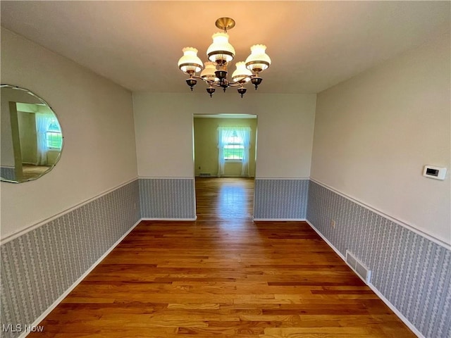 180 Atterbury Blvd, Hudson, OH 44236 - unfurnished dining area with wallpapered walls, wainscoting, wood finished floors, and a chandelier