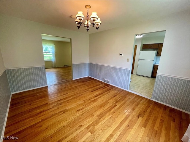 180 Atterbury Blvd, Hudson, OH 44236 - unfurnished room with light wood-style floors, wainscoting, a chandelier, and baseboards