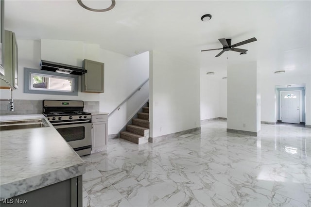 90 Frank St, Struthers, OH 44471 - kitchen with gas stove, exhaust hood, a ceiling fan, a sink, and light countertops