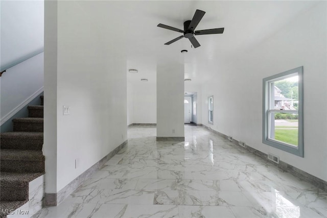90 Frank St, Struthers, OH 44471 - unfurnished living room featuring baseboards, stairs, a ceiling fan, and light marble finish floors