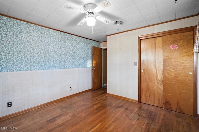 12873 Unity Rd, New Springfield, OH 44443 - unfurnished bedroom with wallpapered walls, hardwood / wood-style flooring, crown molding, wainscoting, and ceiling fan
