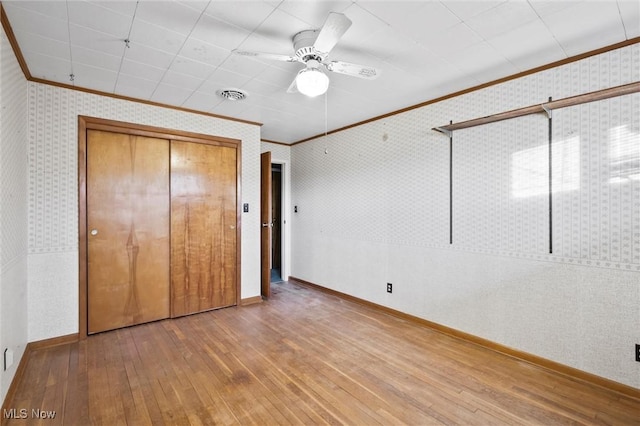 12873 Unity Rd, New Springfield, OH 44443 - unfurnished bedroom featuring ornamental molding, hardwood / wood-style floors, a closet, ceiling fan, and wallpapered walls