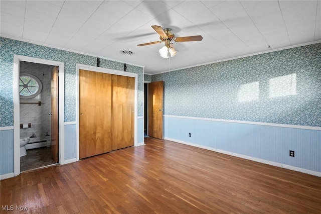 12873 Unity Rd, New Springfield, OH 44443 - unfurnished bedroom featuring wallpapered walls, wood finished floors, a wainscoted wall, crown molding, and a baseboard heating unit