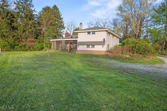12873 Unity Rd, New Springfield, OH 44443 - back of property with a chimney, a sunroom, and a lawn