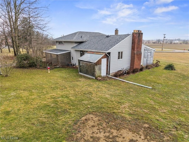 12873 Unity Rd, New Springfield, OH 44443 - rear view of property with a lawn, an outdoor structure, and roof with shingles