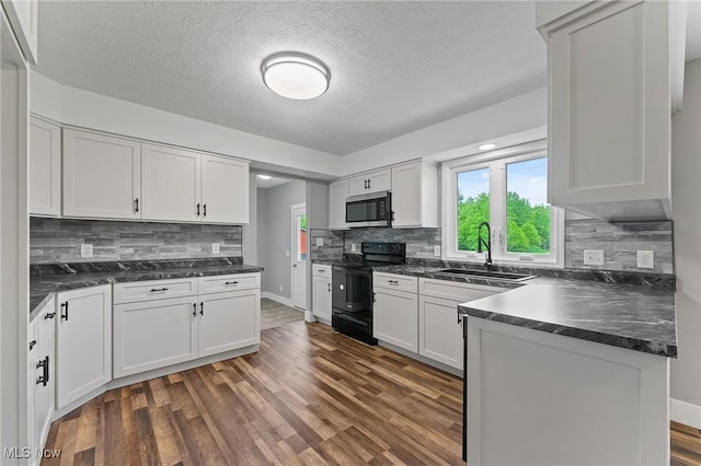 3371 Padanarum Rd, Geneva, OH 44041 - kitchen featuring black electric range, stainless steel microwave, dark countertops, and a textured ceiling