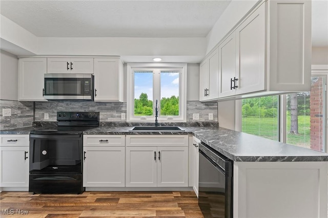 3371 Padanarum Rd, Geneva, OH 44041 - kitchen with stainless steel appliances, a sink, white cabinetry, and light wood-style flooring