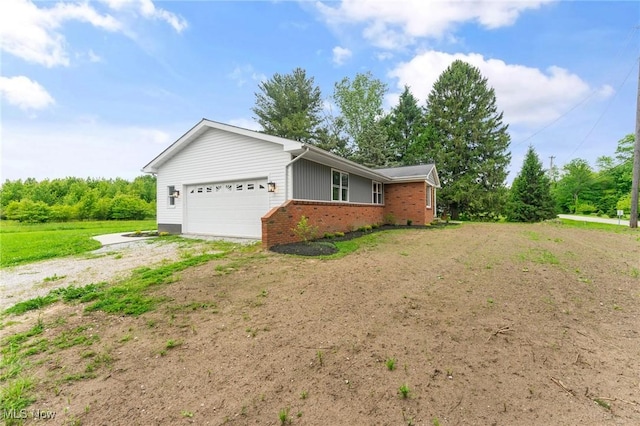 3371 Padanarum Rd, Geneva, OH 44041 - view of home's exterior featuring driveway, a garage, and brick siding