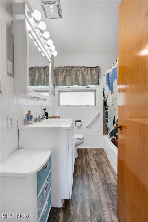 525 Hill Blvd, East Liverpool, OH 43920 - bathroom featuring vanity, toilet, wood finished floors, and shower / bathtub combination with curtain