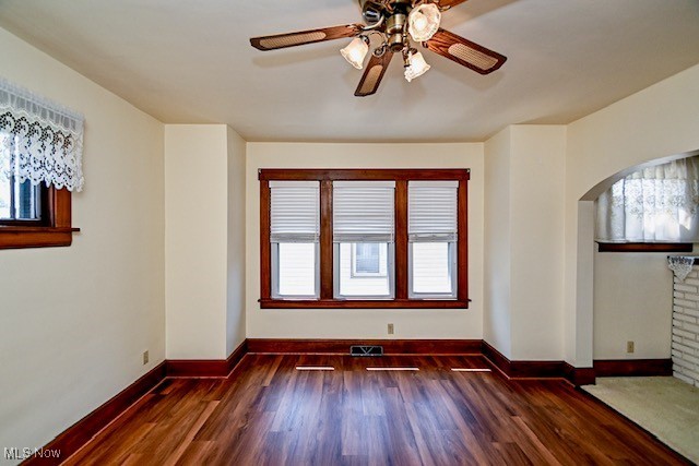 837 Lake Ave NE, Massillon, OH 44646 - empty room featuring arched walkways, healthy amount of natural light, a ceiling fan, and wood finished floors