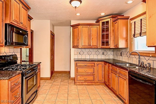 837 Lake Ave NE, Massillon, OH 44646 - kitchen with black appliances, dark stone countertops, a sink, decorative backsplash, and brown cabinets