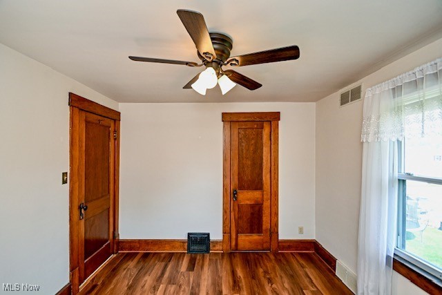 837 Lake Ave NE, Massillon, OH 44646 - unfurnished room featuring baseboards, dark wood-type flooring, and a ceiling fan