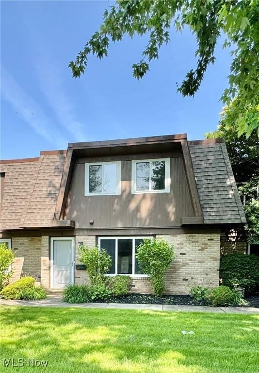 6400 Center St Unit 14, Mentor, OH 44060 - rear view of house featuring brick siding, a lawn, and roof with shingles