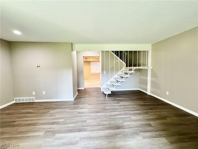 6400 Center St Unit 14, Mentor, OH 44060 - spare room featuring baseboards, stairs, wood finished floors, and a textured ceiling