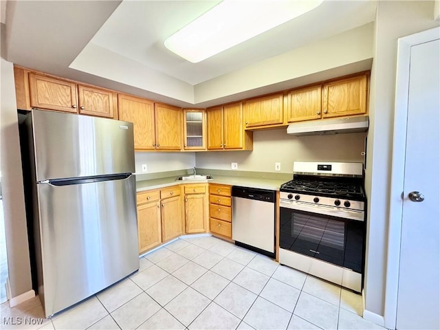 6400 Center St Unit 14, Mentor, OH 44060 - kitchen featuring stainless steel appliances, under cabinet range hood, light countertops, light tile patterned flooring, and a tray ceiling
