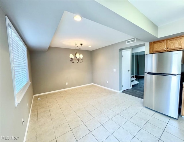6400 Center St Unit 14, Mentor, OH 44060 - kitchen with freestanding refrigerator, light tile patterned floors, baseboards, a chandelier, and brown cabinetry