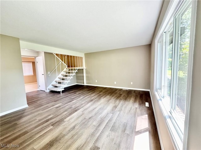6400 Center St Unit 14, Mentor, OH 44060 - unfurnished living room featuring wood finished floors, stairway, and baseboards