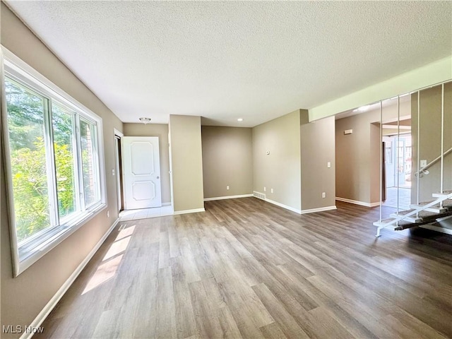 6400 Center St Unit 14, Mentor, OH 44060 - empty room with plenty of natural light, wood finished floors, a textured ceiling, and baseboards