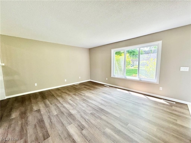 6400 Center St Unit 14, Mentor, OH 44060 - spare room featuring wood finished floors, baseboards, and a textured ceiling