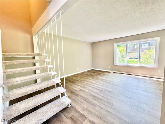 6400 Center St Unit 14, Mentor, OH 44060 - stairway featuring wood finished floors, baseboards, and a textured ceiling