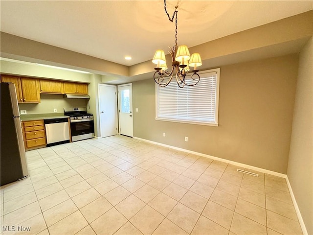 6400 Center St Unit 14, Mentor, OH 44060 - kitchen featuring appliances with stainless steel finishes, a chandelier, under cabinet range hood, brown cabinets, and light tile patterned floors
