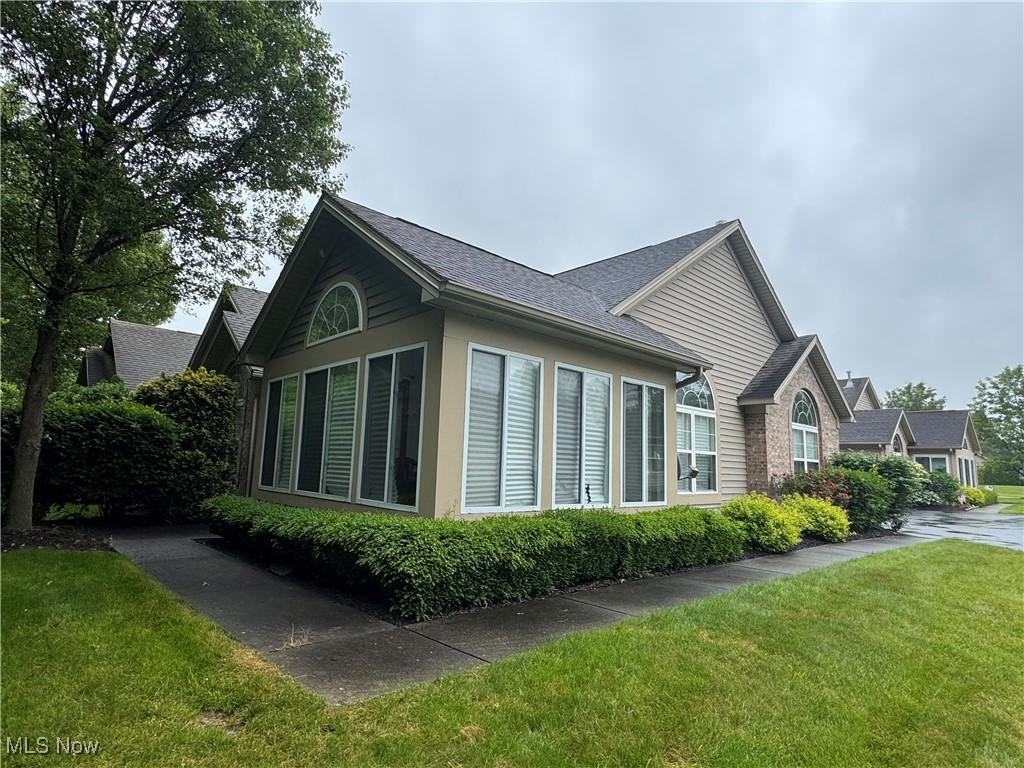 1303 Willow Brook Dr NE, Warren, OH 44483 - view of property exterior featuring a yard and a shingled roof