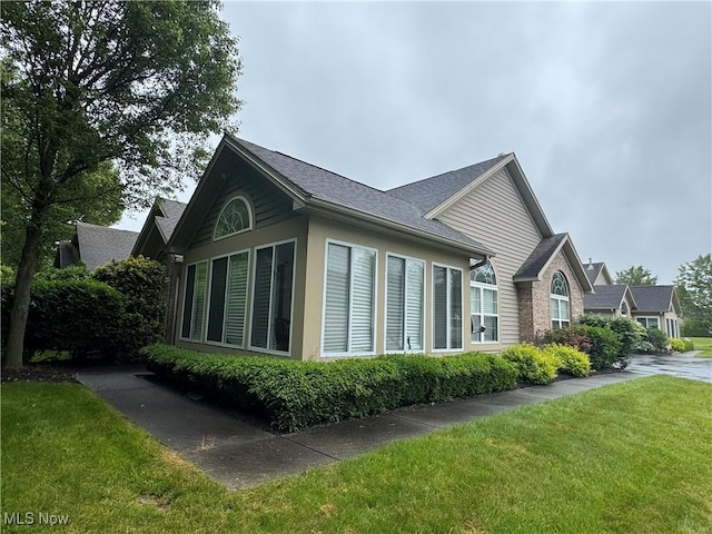 1303 Willow Brook Dr NE, Warren, OH 44483 - view of property exterior featuring a yard and a shingled roof