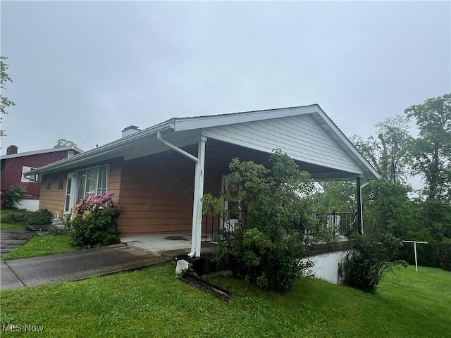 156 Andover Rd, Woodsfield, OH 43793 - view of property exterior with a yard, driveway, and a chimney