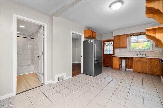 348 Elberta Dr, Vermilion, OH 44089 - kitchen with freestanding refrigerator, a sink, light countertops, light tile patterned floors, and brown cabinets