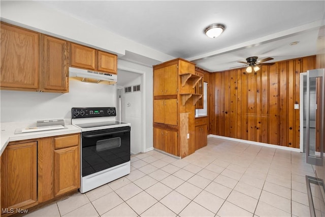 348 Elberta Dr, Vermilion, OH 44089 - kitchen with range with electric cooktop, under cabinet range hood, ceiling fan, light countertops, and brown cabinetry