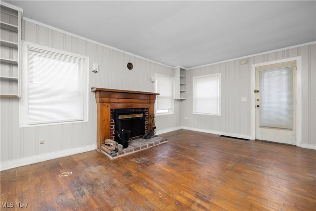 348 Elberta Dr, Vermilion, OH 44089 - unfurnished living room with ornamental molding, hardwood / wood-style flooring, built in features, baseboards, and a wood stove