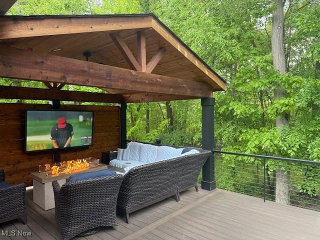 4340 Castlegate Blvd, Uniontown, OH 44685 - deck with a gazebo, an outdoor living space with a fire pit, and a forest view