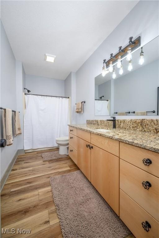 4340 Castlegate Blvd, Uniontown, OH 44685 - bathroom featuring wood finished floors, vanity, toilet, and a shower with shower curtain