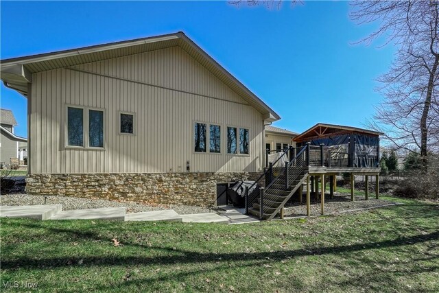 4340 Castlegate Blvd, Uniontown, OH 44685 - back of house with a deck, stairway, a lawn, and stone siding