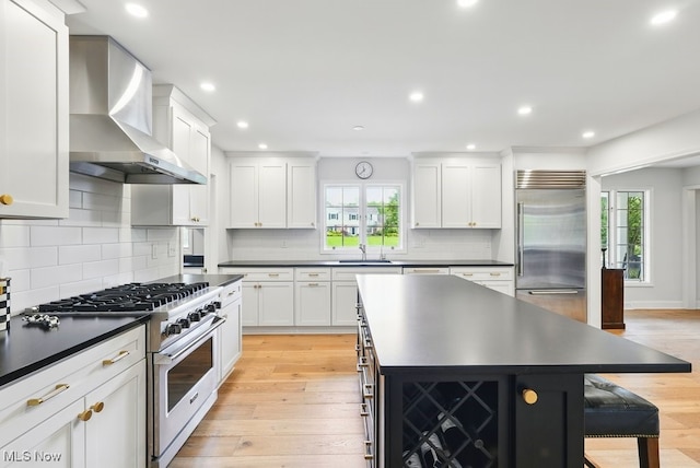 19 Brandywood Dr, Pepper Pike, OH 44124 - kitchen with wall chimney range hood, premium appliances, dark countertops, a sink, and recessed lighting
