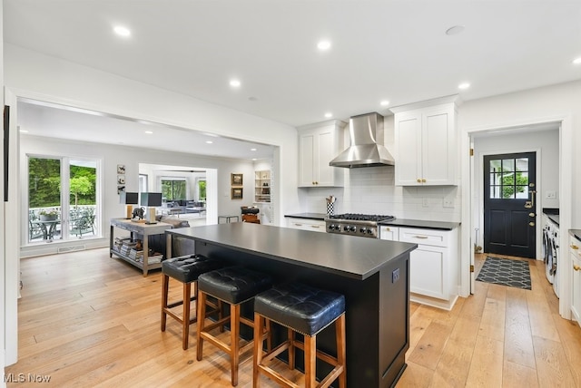 19 Brandywood Dr, Pepper Pike, OH 44124 - kitchen with wall chimney exhaust hood, dark countertops, light wood-style floors, white cabinets, and recessed lighting