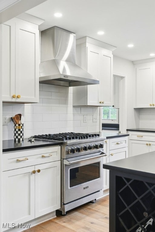 19 Brandywood Dr, Pepper Pike, OH 44124 - kitchen featuring wall chimney range hood, stainless steel stove, dark countertops, decorative backsplash, and recessed lighting