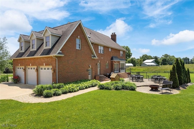 5495 Meese Rd NE, Louisville, OH 44641 - view of home's exterior with an outdoor fire pit, brick siding, concrete driveway, a chimney, and an attached garage