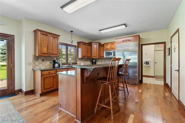 5495 Meese Rd NE, Louisville, OH 44641 - kitchen with built in appliances, light wood finished floors, and brown cabinetry