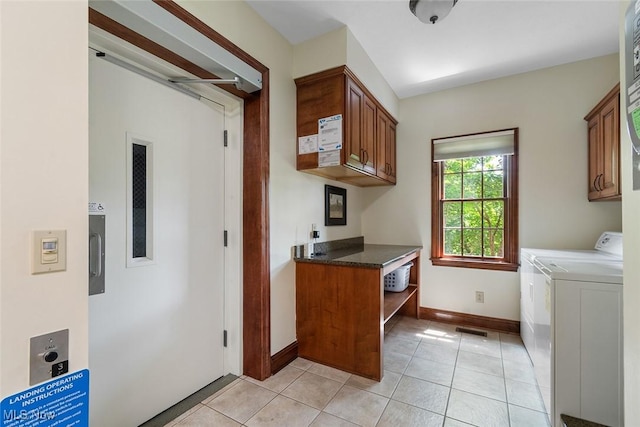 5495 Meese Rd NE, Louisville, OH 44641 - washroom featuring cabinet space, independent washer and dryer, baseboards, and light tile patterned flooring
