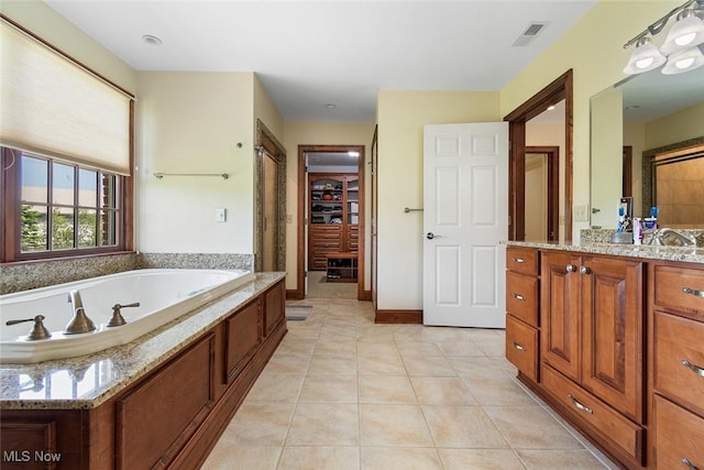 5495 Meese Rd NE, Louisville, OH 44641 - full bathroom with tile patterned floors, vanity, a bath, a walk in closet, and a shower with door