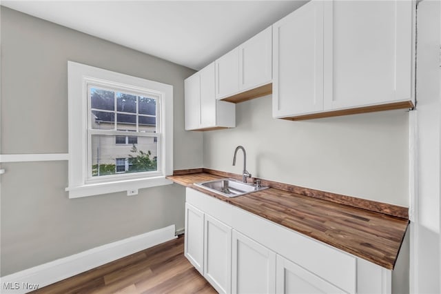 3528 Daleford Rd, Shaker Heights, OH 44120 - kitchen featuring a sink, white cabinetry, butcher block counters, and light wood finished floors