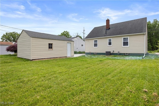 1731 E 36th St, Lorain, OH 44055 - rear view of property featuring a yard, an outbuilding, a chimney, and central AC unit