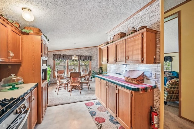 1270 S Lincoln Ave Unit A, Salem, OH 44460 - kitchen with light carpet, a textured ceiling, crown molding, brown cabinetry, and decorative light fixtures
