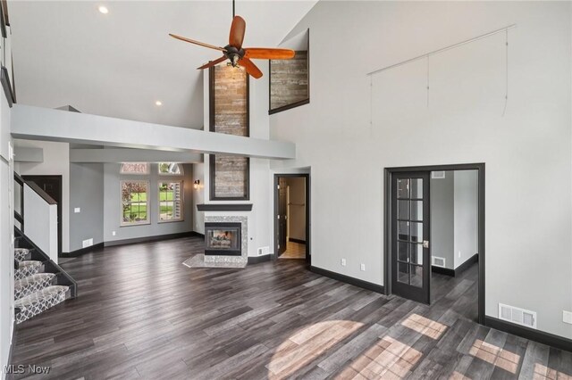 322 N Bayshore Dr Unit 3, Columbiana, OH 44408 - unfurnished living room with high vaulted ceiling, wood finished floors, ceiling fan, a stone fireplace, and baseboards