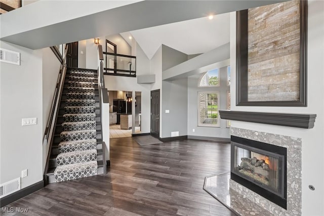 322 N Bayshore Dr Unit 3, Columbiana, OH 44408 - unfurnished living room with stairway, wood finished floors, baseboards, a multi sided fireplace, and high vaulted ceiling